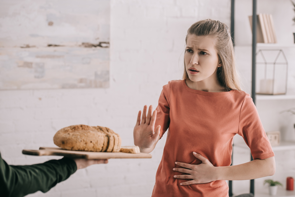 Žena odmítající gestem nabízený chléb na prkénku