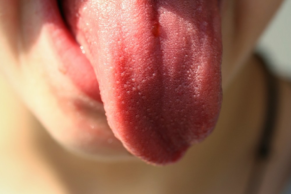 Detail vyplazeného zdravého jazyka růžové barvy bez povlaku