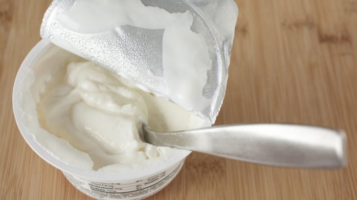 Bílý jogurt v kelímku se lžící