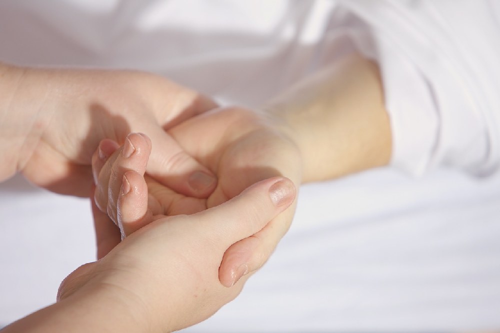 Detailní záběr masáže rukou a zjišťování její citlivosti při nedostatku vitamínu E
