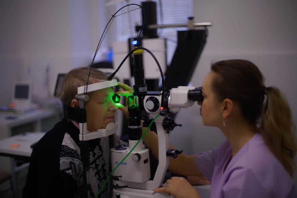 Pacient na vyšetření očním přístrojem u oftalmoložky
