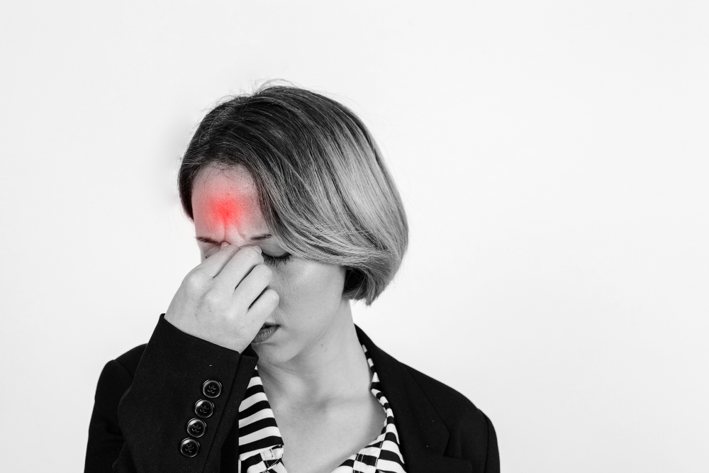 Žena s migrénou se drží za čelo