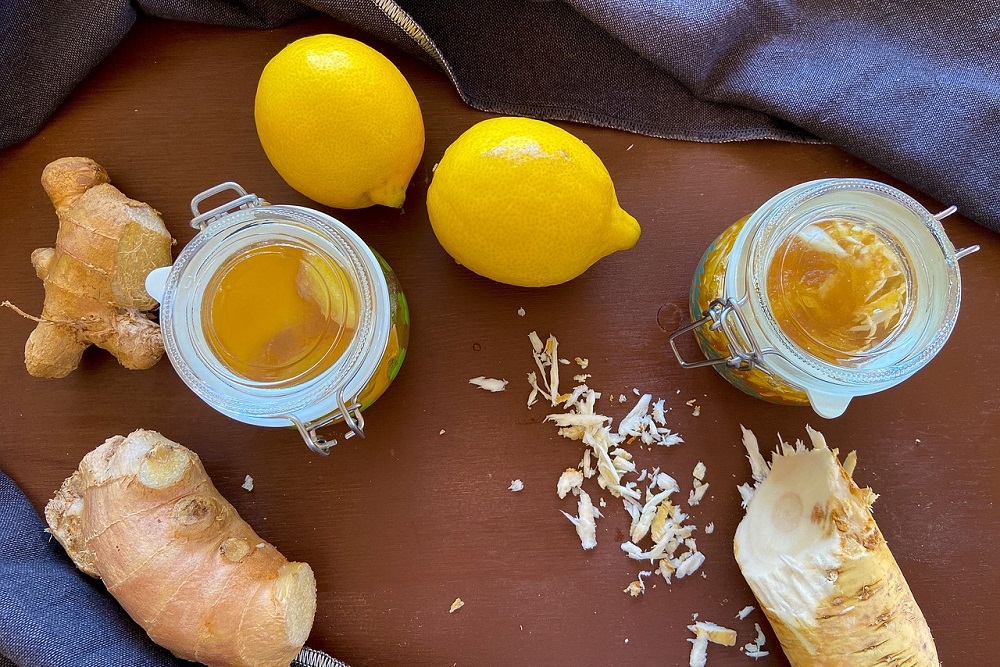 Citrony, med, zázvor a křen připravené na prkénku