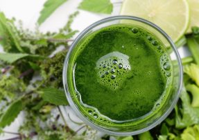 Pohled shora do sklenice se zeleným nápojem pro detoxikaci