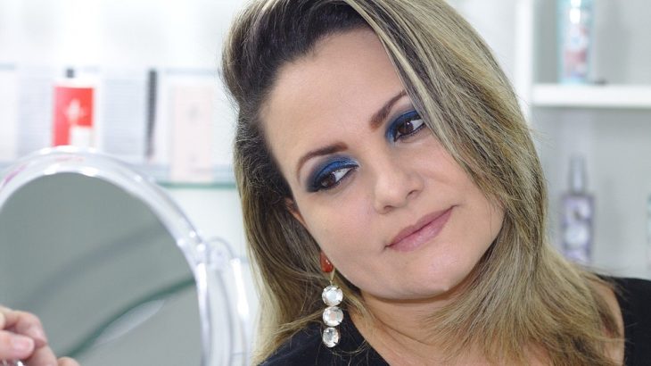 Nalíčená žena koukající se do zrcadla