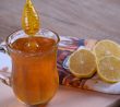 Med ve sklenici s rozpůlenými citrony na utěrce