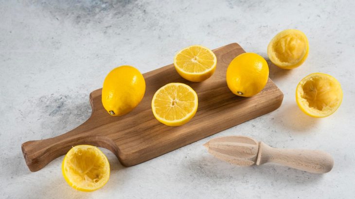 Celé, nakrájené a odšťavněné citrony na prkénku