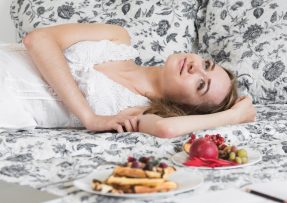 Žena v posteli s jídlem