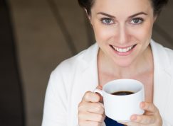 Umívající se žena s hrnkem kávy v ruce