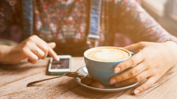 Žena s ranní kávou a mobilem