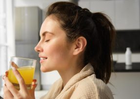 Mladá žena pijící limonádu poránu v kuchyni