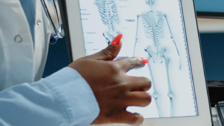 Lékařka ukazuje na kostru na tabletu